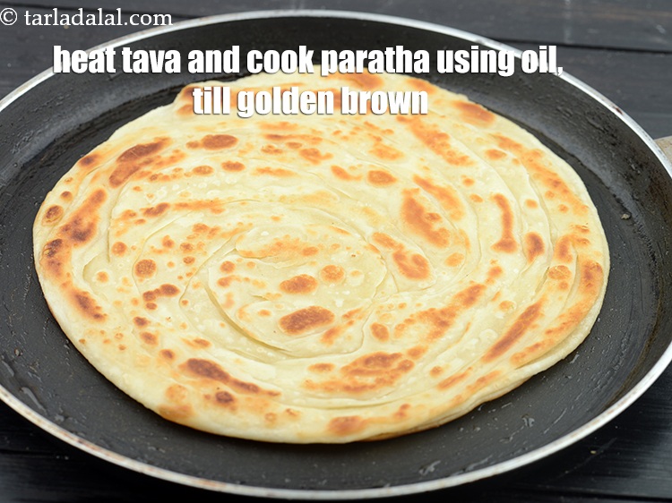 Step 46 – Heat a non-stick tava (griddle) and cook the paratha by gently pressing it, using 2 …