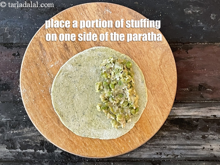 Step 39 – <meta charset="UTF-8" />Place a portion of the stuffing on one halve of the rolled roti.