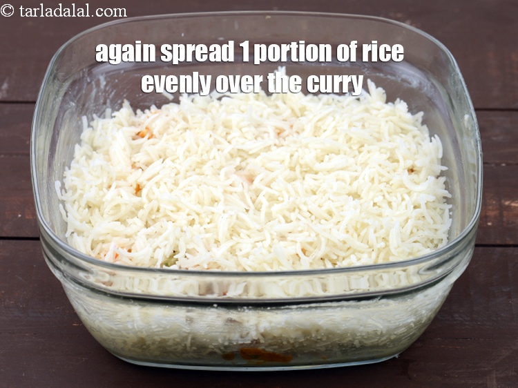 Step 41 – Again spread 1 portion of rice evenly over the curry.