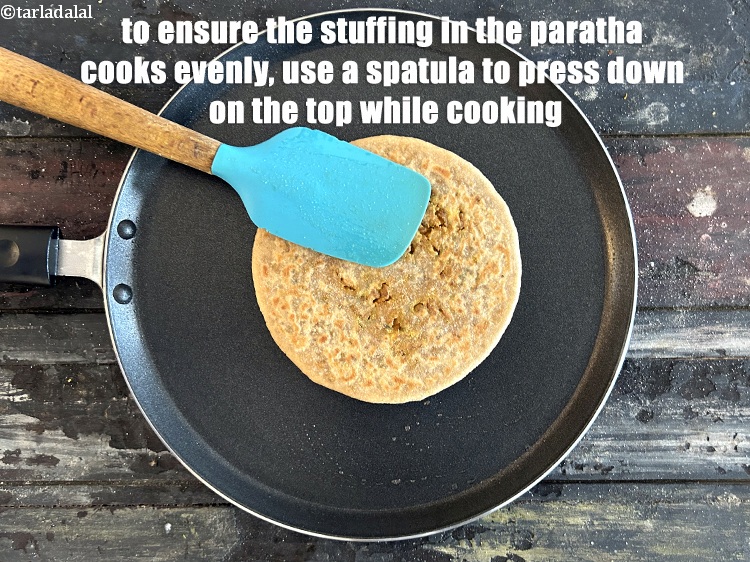 Step 51 – <meta charset="UTF-8" />To ensure that the stuffing in the paratha cooks evenly, use a spatula …