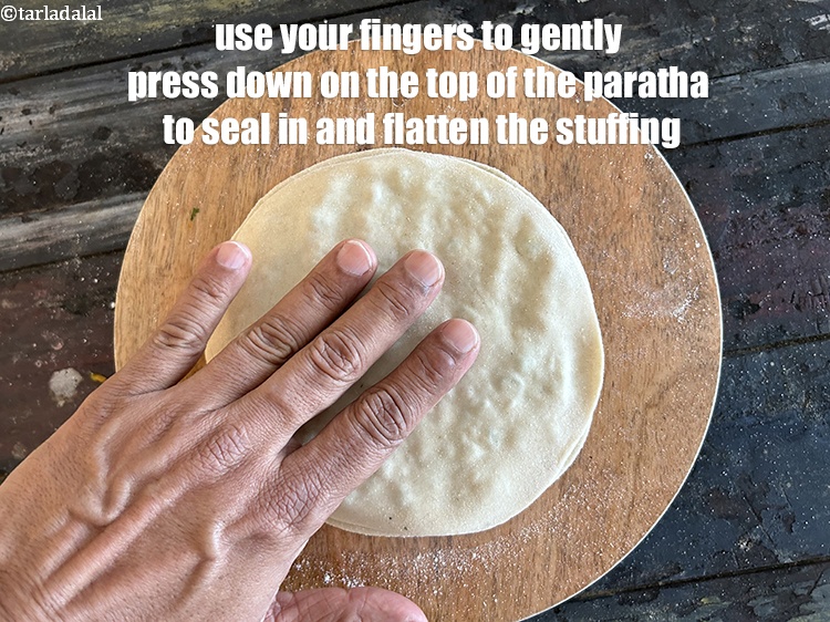 Step 39 – Use your fingers to gently press down on the top of the paratha to seal …