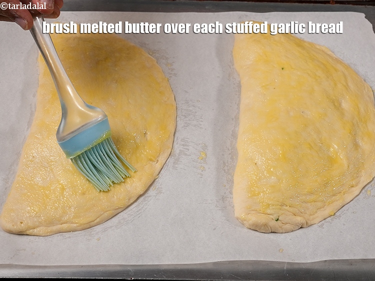Step 42 – Brush &frac12; tbsp&nbsp;<a href="https://www.tarladalal.com/glossary-melted-butter-1941i">melted butter</a> over each stuffed garlic bread.