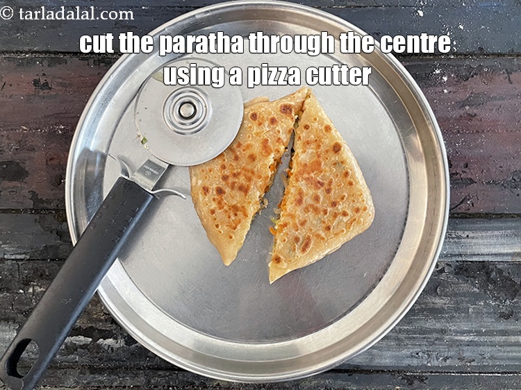 Step 43 – Transfer to a plate and cut the <strong>paneer carrot and bean sprouts paratha</strong>&nbsp;through the centre …