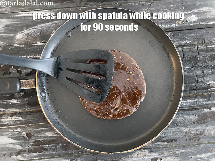 Step 51 – Cook on a low flame for 90 seconds.&nbsp;Remember to keep pressing down on the roti …