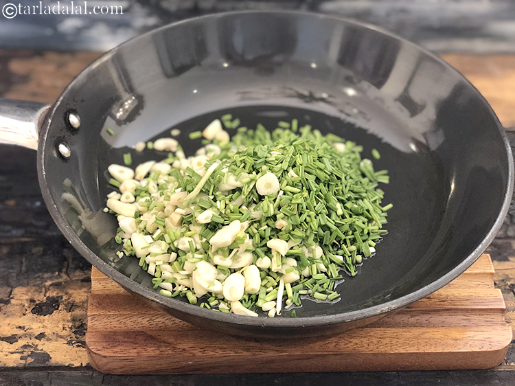 स्टेप 6 – १ कप बारीक कटा हुआ हरा लेहसुन डालें।