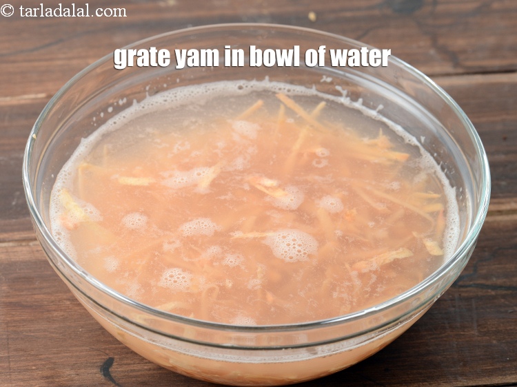 Step 5 – Grate the yam in the bowl of water to avoid discoloration.