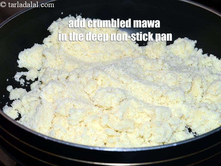 Step 5 – Add 1 &frac12; <a href="https://www.tarladalal.com/glossary-crumbled-mawa-2259i">crumbled mawa (khoya)</a> in the deep non-stick pan.