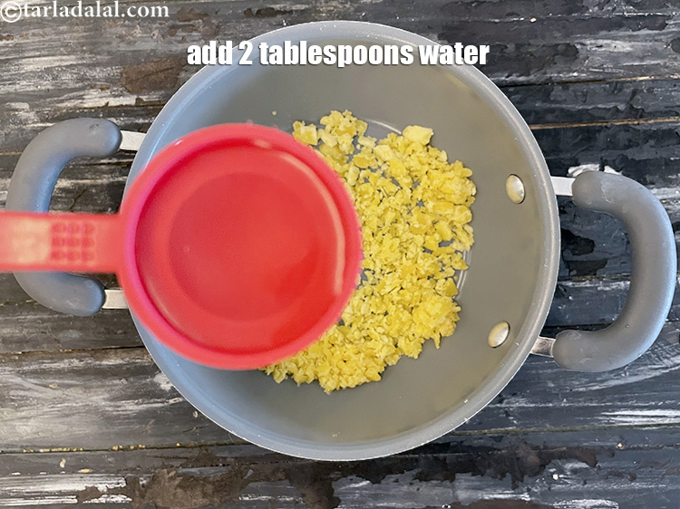 स्टेप 6 – 2 टेबल-स्पू पानी डालें।