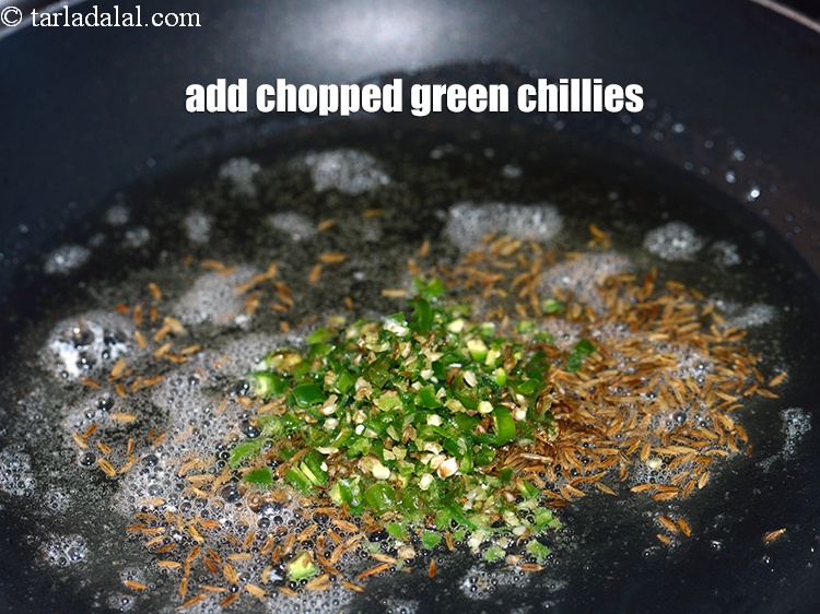 Step 6 – When the seeds crackle, add 1 tbsp <a href="https://www.tarladalal.com/glossary-chopped-green-chilli-820i">chopped green chillies</a>.&nbsp;