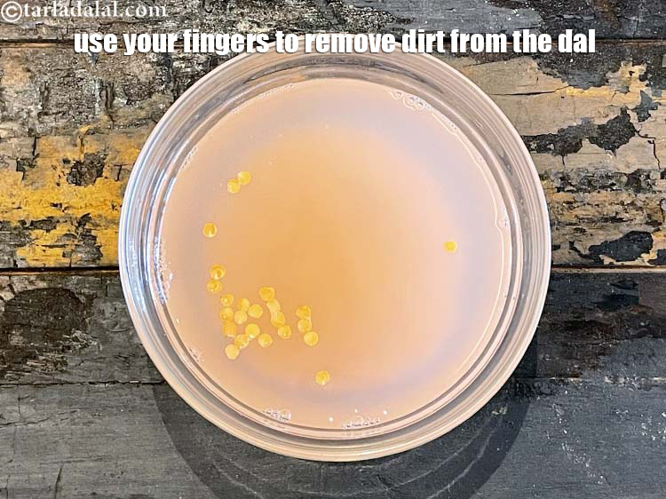 Step 6 – Use your fingers to remove dirt from the dal. You can see the water turning …
