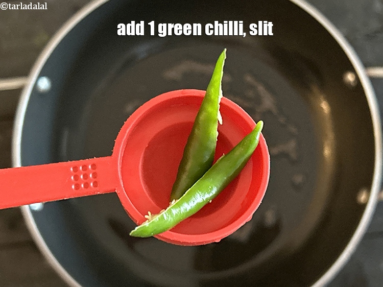 स्टेप 10 – १&nbsp;<a href=""https://www.tarladalal.com/glossary-green-chillies-hari-mirch-hindi-331i"">हरी मिर्च</a>&nbsp;, चीरा हुआ&nbsp;डालें।