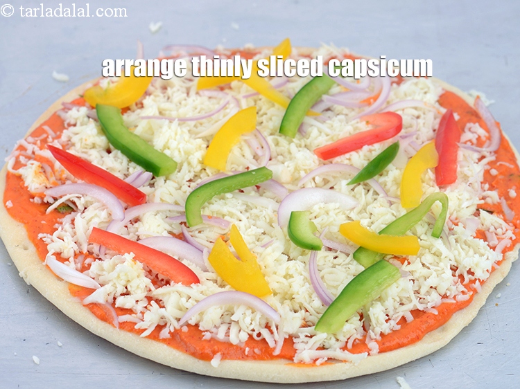 Step 44 – Arrange &frac14; cup thinly <a href="https://www.tarladalal.com/glossary-sliced-coloured-capsicum-2803i">sliced coloured capsicum</a> evenly over it.&nbsp;