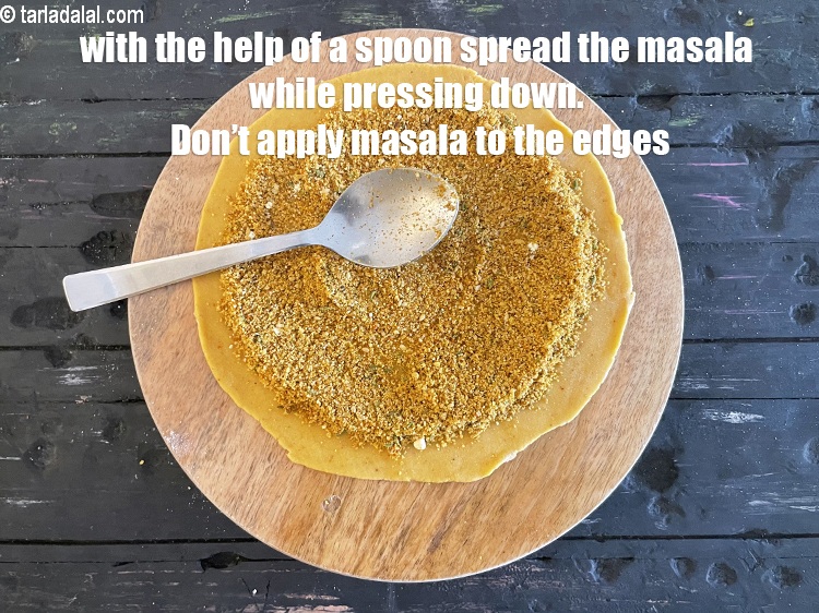 Step 42 – Pat masala&nbsp;lightly while leaving a little space at the circumference. Use a spoon to help …