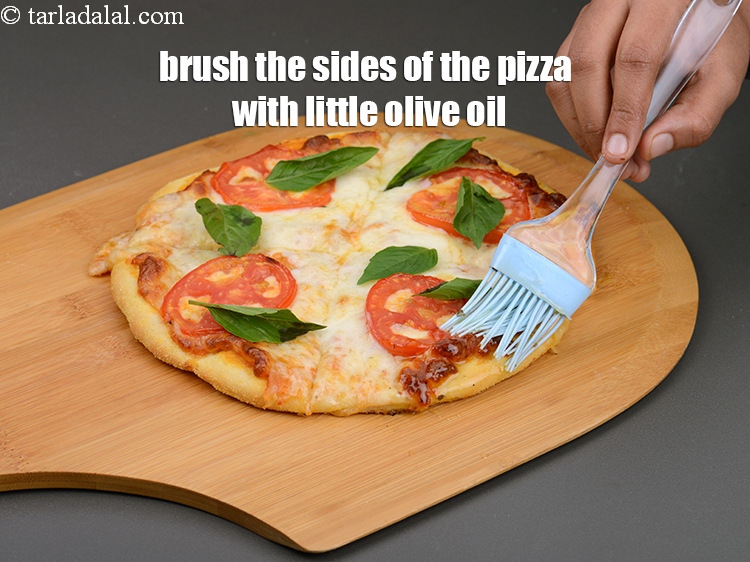 Step 44 – Brush the sides of the pizza with little&nbsp;<a href="https://www.tarladalal.com/glossary-olive-oil-451i">olive oil</a>.