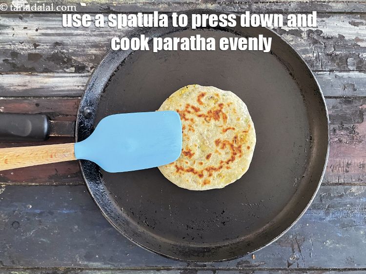 Step 58 – Use a spatula to press down on the paratha to cook it evenly.