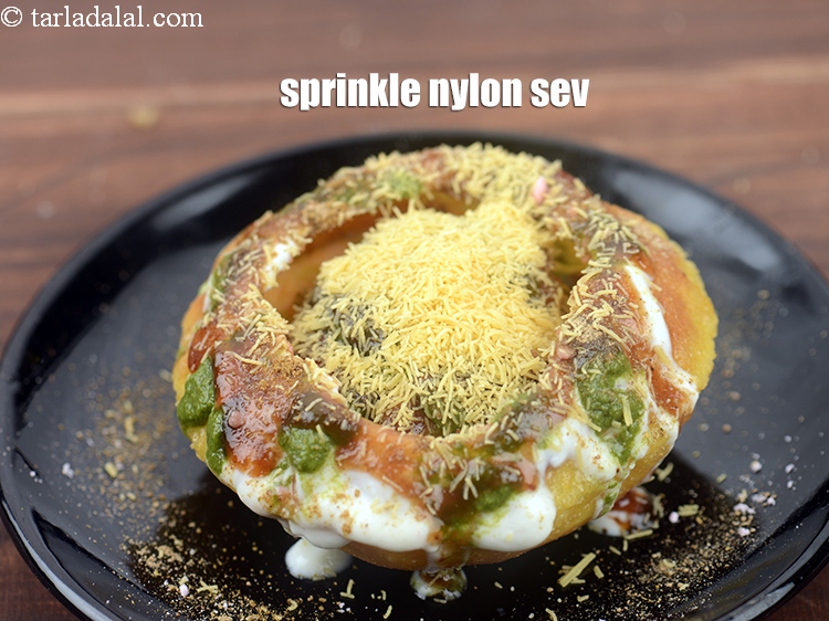 Step 52 – Sprinkle 2 tbsp&nbsp;<a href="https://www.tarladalal.com/glossary-nylon-sev-2630i">nylon sev</a>&nbsp;over the kachori.