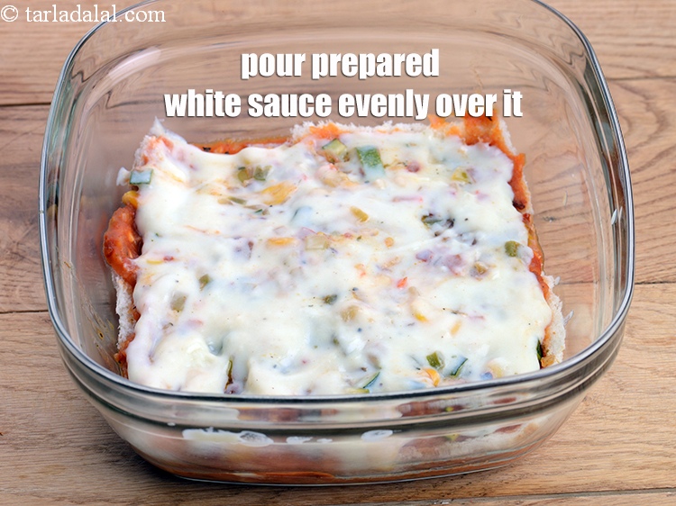 Step 50 – Pour &frac14; cup of prepared white sauce evenly over it and spread it.