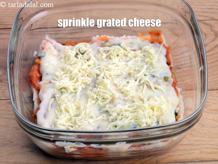 Step 51 – Sprinkle &frac14; cup of <a href="https://www.tarladalal.com/glossary-grated-processed-cheese-868i">grated processed cheese</a> evenly over it.