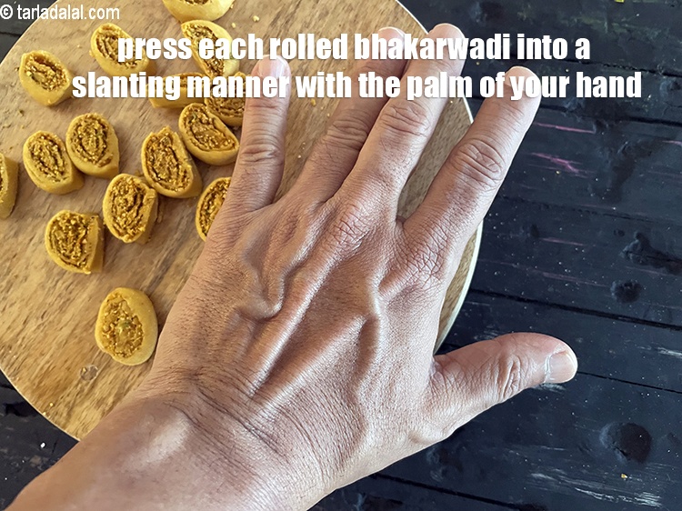 Step 50 – Press each rolled bhakarwadi in a slanting manner using your palm.