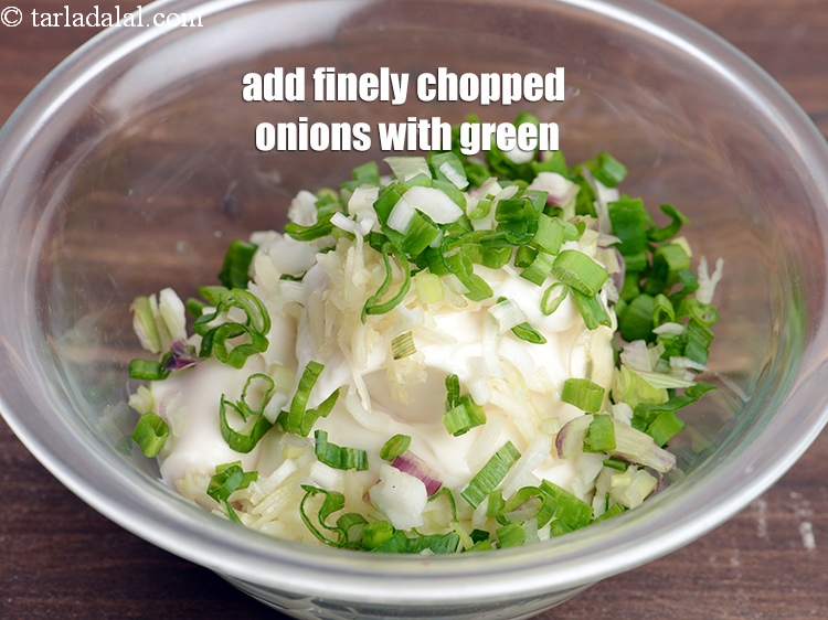 Step 6 – Add &frac14; cup finely <a href="https://tarladalal.com/glossary-chopped-onions-722i">chopped onions</a>&nbsp;with greens.