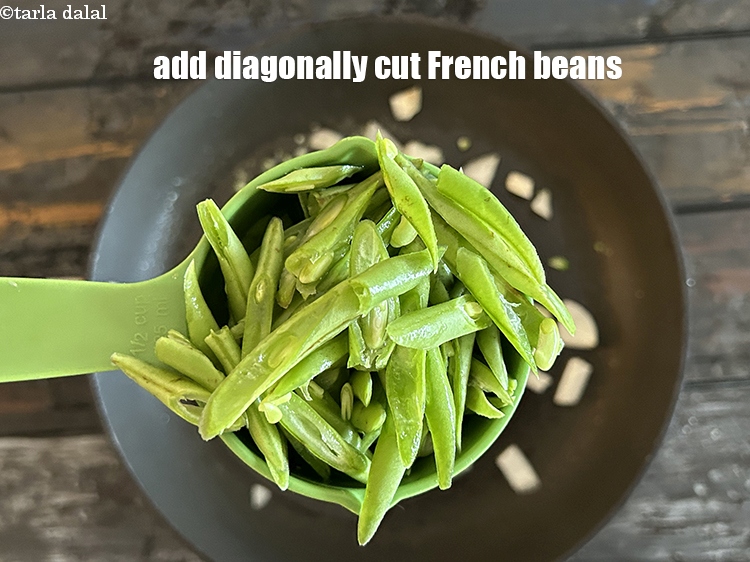 स्टेप 10 – १/२ कप&nbsp;<a href=""https://www.tarladalal.com/glossary-diagonally-cut-french-beans-hindi-2461i"">पतले तिरछे कटे हुए फ्रेंच बीन्स</a>&nbsp;डालें।