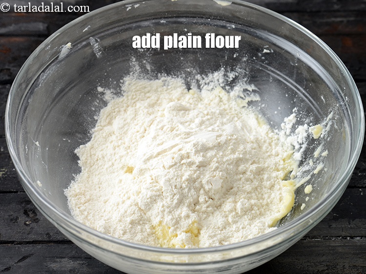 Step 6 – Add &frac12; cup <a href="https://www.tarladalal.com/glossary-plain-flour-maida-188i">plain flour (maida)</a>