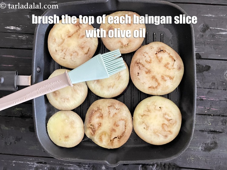 Step 8 – Brush the top of each baingan slice with olive oil.