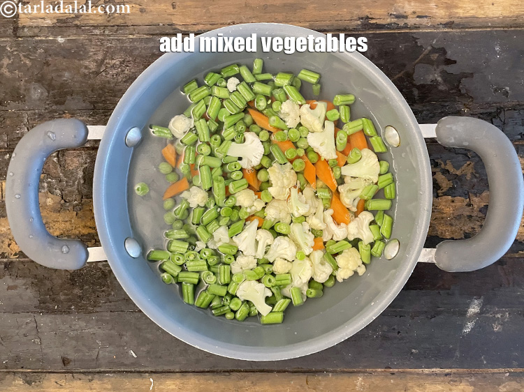 स्टेप 6 – मिक्स सब्जियाँ डालें।