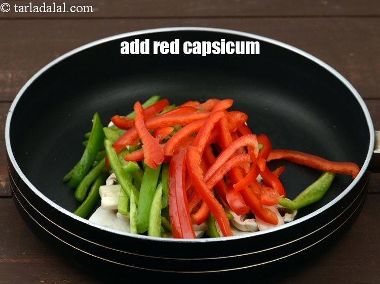 Step 14 – Add 1/2 cup&nbsp;<a href="https://www.tarladalal.com/glossary-sliced-red-capsicum-2176i">sliced red capsicum</a>.