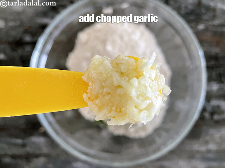स्टेप 10 – १/२ टी-स्पून <a href=""https://www.tarladalal.com/glossary-chopped-garlic-hindi-790i"">बारीक कटा हुआ लहसुन</a> डालें।