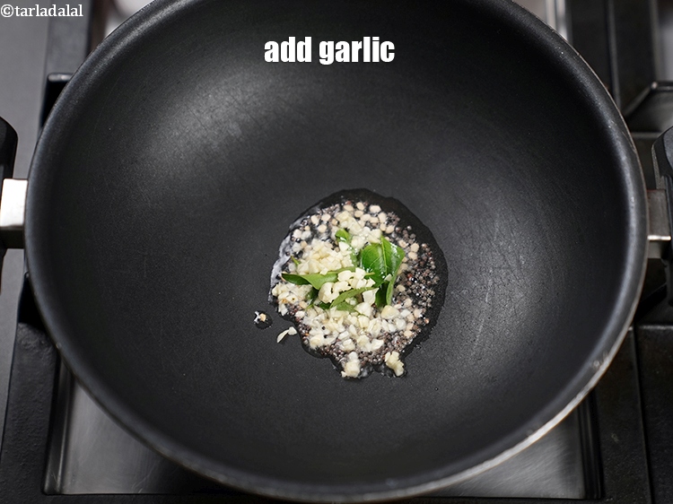 Step 7 – When the seeds crackle, add 1 tsp finely <a href="https://www.tarladalal.com/glossary-chopped-garlic-790i">chopped garlic (lehsun)</a>.