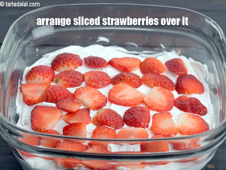 Step 7 – Arrange &frac12; cup <a href="https://www.tarladalal.com/glossary-sliced-strawberries-749i">sliced strawberries</a> evenly over it.