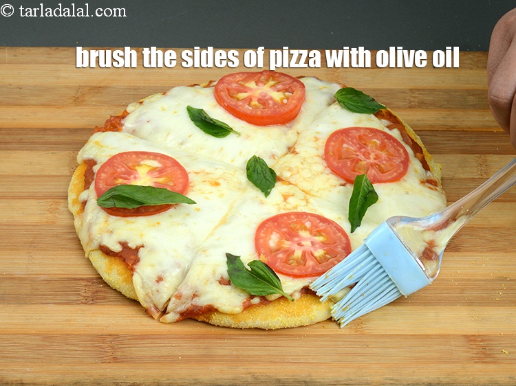 Step 55 – Brush the sides of the pizza with <a href="https://www.tarladalal.com/glossary-olive-oil-451i">olive oil</a>.