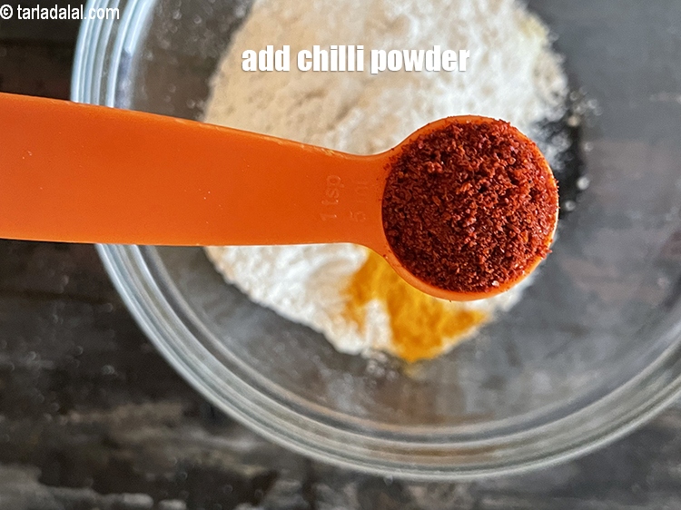 स्टेप 7 – १ टी-स्पून&nbsp;<a href=""https://www.tarladalal.com/glossary-chilli-powder-red-chilli-powder-hindi-339i"">लाल मिर्च पाउडर</a>&nbsp;<span style=""font-size:11.0pt""><span style=""background-color:white""><span style=""font-family:&quot;Nirmala UI&quot;,sans-serif""><span style=""color:black"">डालें।</span></span></span></span>