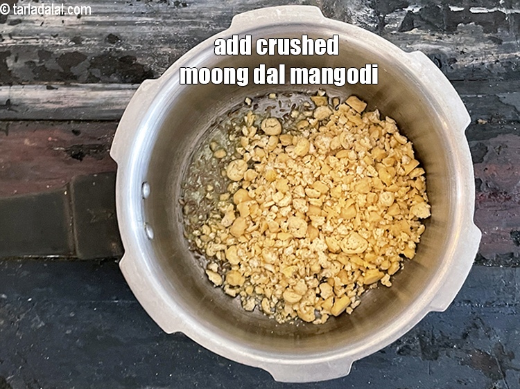 स्टेप 9 – १ कप&nbsp;<a href=""https://www.tarladalal.com/glossary-crushed-mangodi-hindi-2346i"">क्रश की हुई मूंग दाल की मगौड़ी</a>&nbsp;डालें।