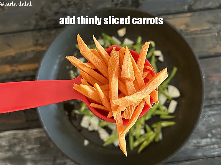 स्टेप 11 – १/४ रेसिपी&nbsp;<a href=""https://www.tarladalal.com/glossary-sliced-carrots-hindi-748i"">पतली कटी हुई गाजर</a>&nbsp;डालें।