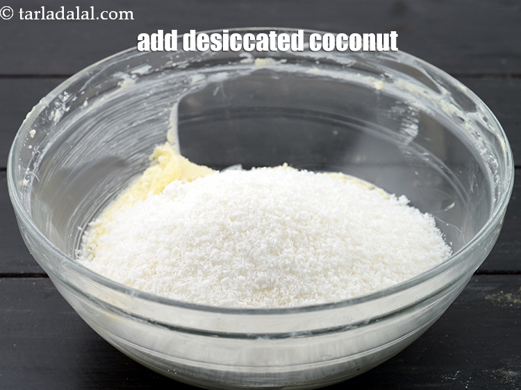 Step 7 – Add 1 cup <a href="https://www.tarladalal.com/glossary-desiccated-coconut-272i">desiccated coconut</a>.