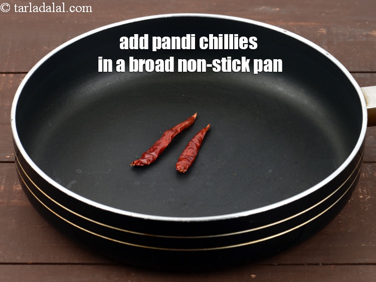Step 8 – In a broad nonstick pan, add 2 to 3 <a href="https://www.tarladalal.com/glossary-pandi-chillies-pandi-dry-red-chillies-2373i">pandi chillies</a>.