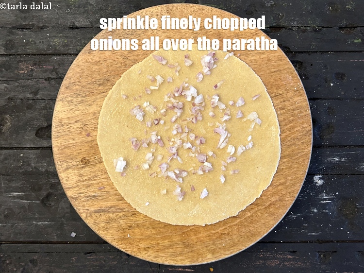 स्टेप 14 – पूरे पराठे पर 1 टेबल-स्पूनबारीक कटा हुआ प्याज छिड़कें।&nbsp;सुनिश्चित करें …