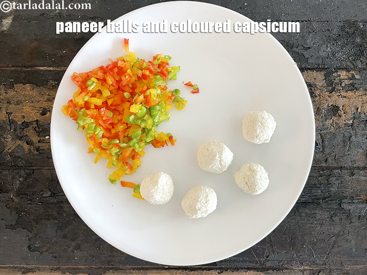 Step 13 – In a plate put the paneer balls and&nbsp;<meta charset="UTF-8" />1/4 cup&nbsp;finely chopped coloured&nbsp;<a href="glossary-capsicum-shimla-mirch-bell-pepper-163i">capsicum</a>.