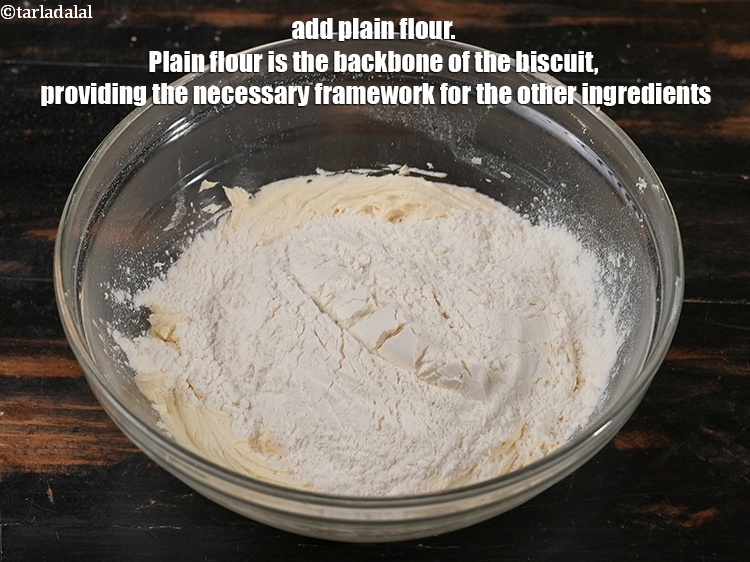 Step 8 – Add 1&frac12; cups <a href="https://www.tarladalal.com/glossary-plain-flour-maida-188i">plain flour (maida)</a>. Plain flour is the backbone of the biscuit, …