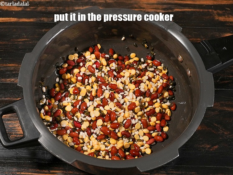 Step 8 – <p>Drain the soaked dals and put it in the pressure cooker.</p>