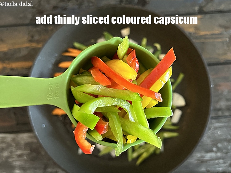 स्टेप 12 – १/२ कप&nbsp;<a href=""https://www.tarladalal.com/glossary-sliced-coloured-capsicum-hindi-2803i"">पतली कटी हुई रंगीन शिमला मिर्च</a>&nbsp;डालें।