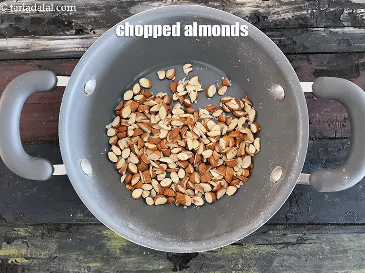 Step 8 – In a deep non-stick pan, put&nbsp;<meta charset="UTF-8" />1/2 cup&nbsp;<a href="glossary-chopped-almonds-865i">chopped almonds (badam)</a>.