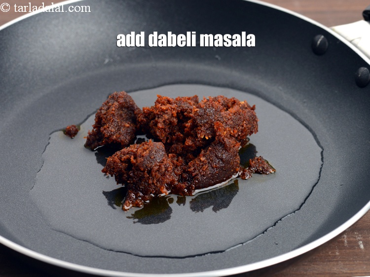 Step 8 – Add 2 &frac12; tbsp <a href="https://www.tarladalal.com/glossary-dabeli-masala-295i">dabeli masala</a>.