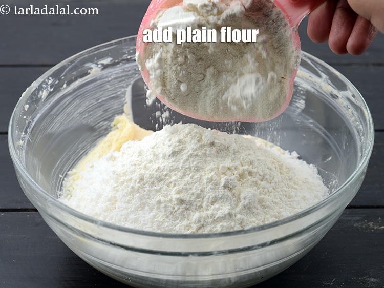 Step 8 – Add 1 cup <a href="https://www.tarladalal.com/glossary-plain-flour-maida-188i">plain flour (maida)</a>.