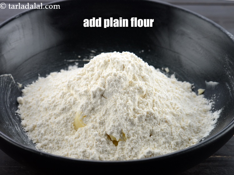 Step 8 – Add 1 3/4 cups&nbsp;<a href="https://www.tarladalal.com/glossary-plain-flour-maida-188i">plain flour (maida)</a>.