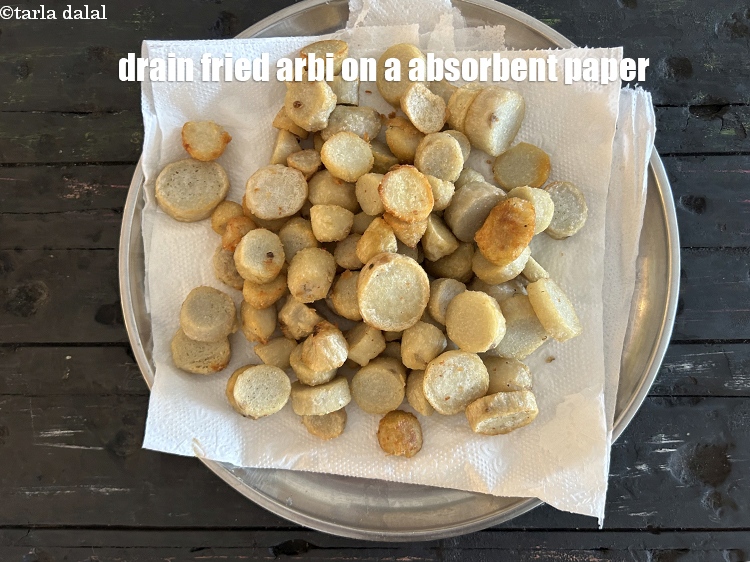 स्टेप 9 – तली हुई अरबी को टिशु पेपर पर निकाल लें और …