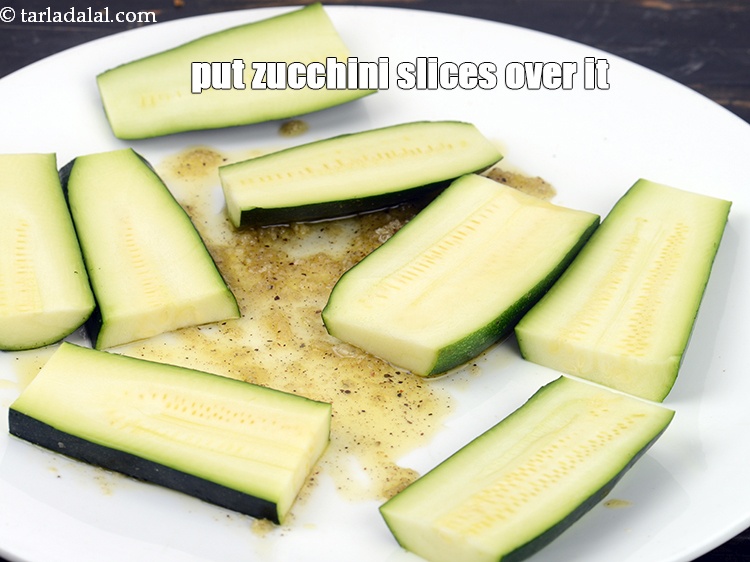 Step 8 – Put 10&nbsp;<a href="https://www.tarladalal.com/glossary-zucchini-slices-2561i">zucchini slices</a> over it.