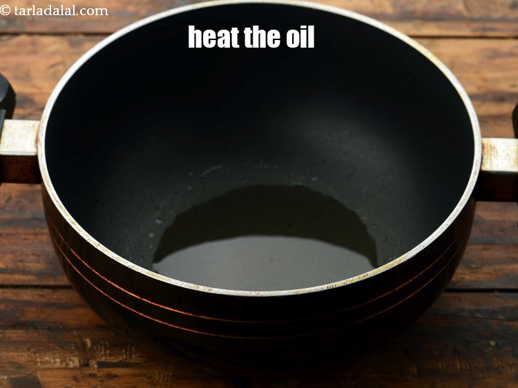 Step 17 – To make coconut kadhi, heat the <a href="https://www.tarladalal.com/glossary-oil-671i" target="_blank">oil</a> in a deep non-stick pan.
